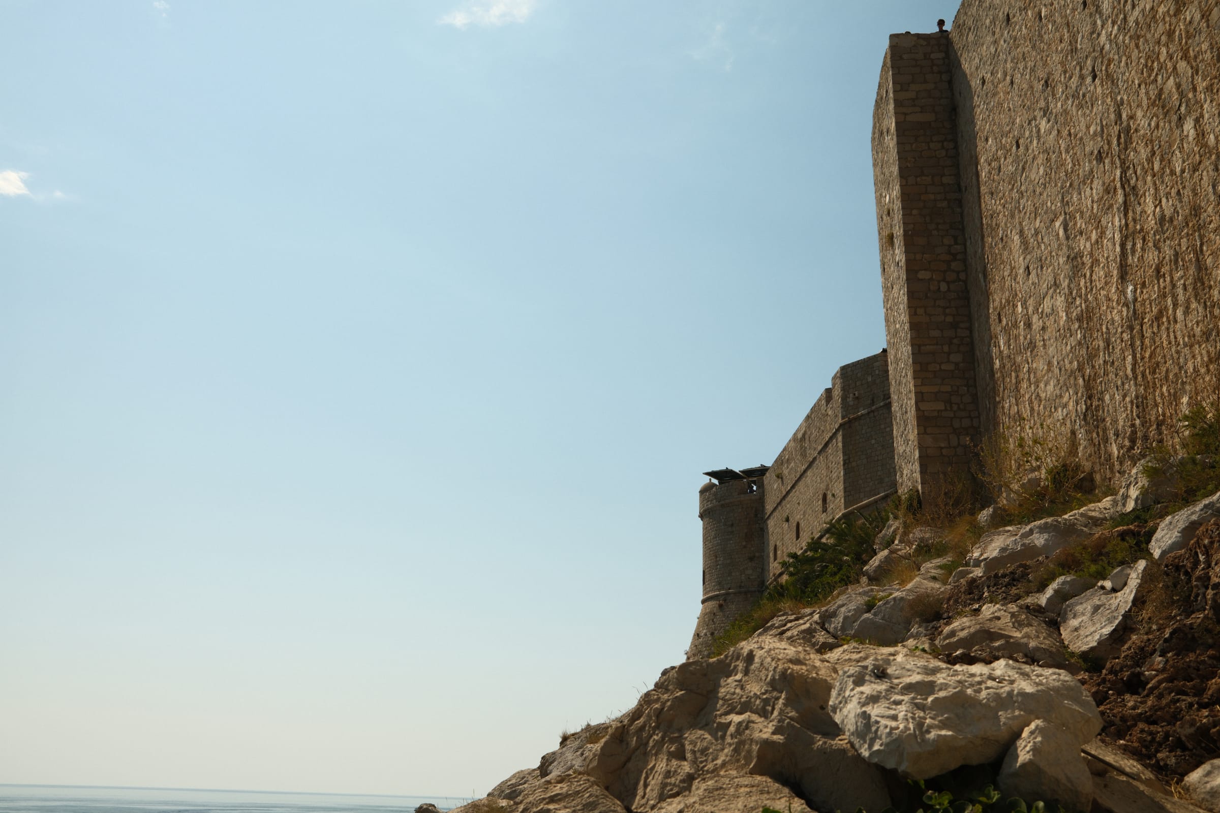 Dubrovnik's city walls seen from the rocks below, with the Adriatic beyond